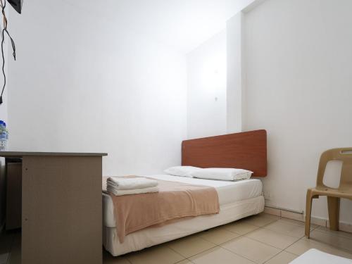 1 dormitorio con 1 cama, 1 mesa y 1 silla en Amrise Hotel 12 en Singapur