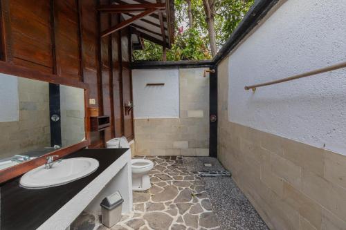 a bathroom with a sink and a toilet at Omah Gili Hotel in Gili Air