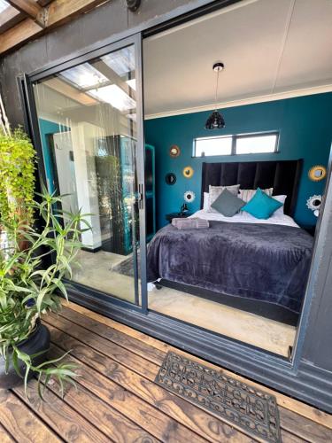 um quarto com uma cama e uma porta de vidro deslizante em Into The Mystic em Cidade do Cabo