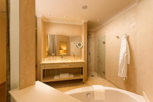 a bathroom with a tub and a sink and a mirror at Alter Meierhof Glücksburg in Glücksburg