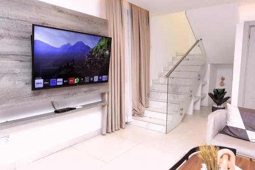 a living room with a flat screen tv on a wall at Luna Loft in Tema