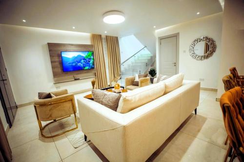a living room with a white couch and a tv at Luna Loft in Tema