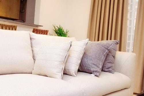 a white couch with several pillows on it at Luna Loft in Tema