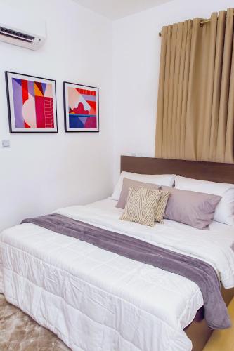 a large white bed in a room with pictures on the wall at Luna Loft in Tema