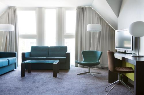a living room with a couch and a table and chairs at Comfort Hotel Kristiansand in Kristiansand