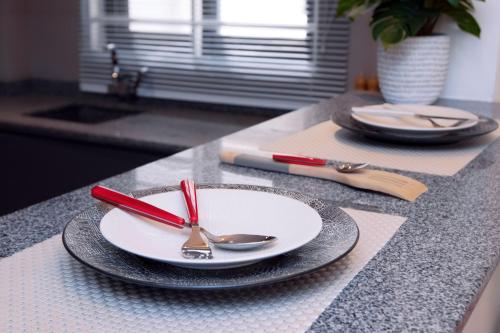 a table with plates and spoons on a counter at Luna Loft in Tema