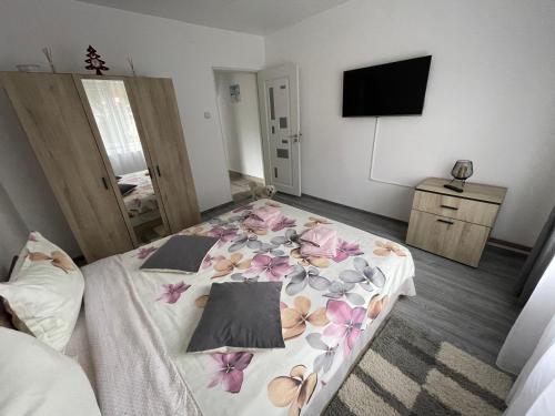 a bedroom with a bed with flowers on it at AKY Residence in Slănic-Moldova