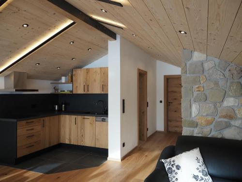eine Küche und ein Wohnzimmer mit einer Steinmauer in der Unterkunft Ferienwohnungen Alpinum in Krün