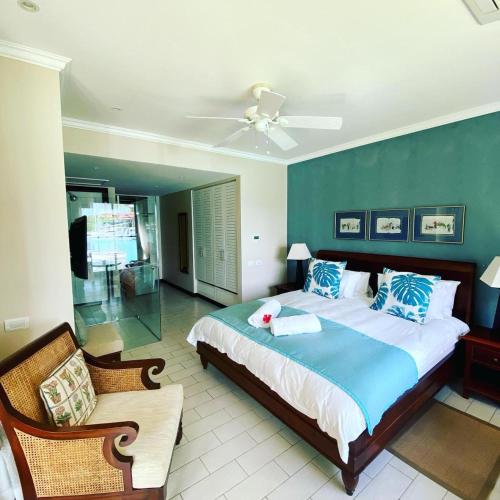 a bedroom with a large bed with a blue wall at Eden Island Luxury Accommodation in Eden Island