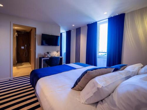 a bedroom with two beds with blue walls and a window at HOTEL LA MARINE in Groix