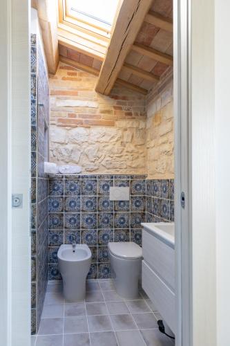 a bathroom with a toilet and a tub and a sink at Il Fiore del Conero in Sirolo