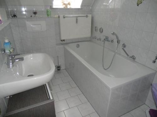 y baño con ducha, bañera y lavamanos. en Ferienwohnung Unger en Stützengrün