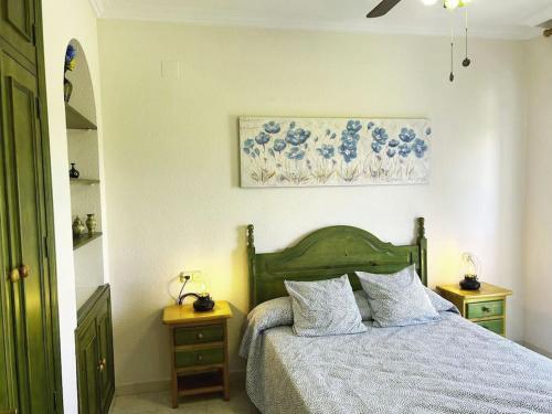 een slaapkamer met een bed en een schilderij aan de muur bij LIFE APARTMENTS EL PORTIL in El Portil