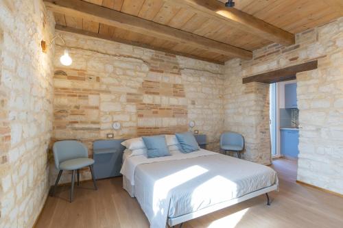 a bedroom with a bed in a stone wall at Il Fiore del Conero in Sirolo