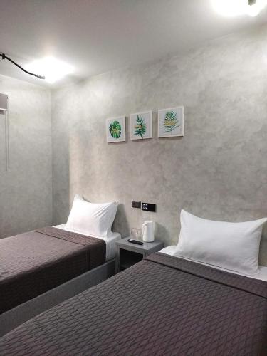 a hotel room with two beds and three pictures on the wall at Kasa Boutique Hotel in Cebu City