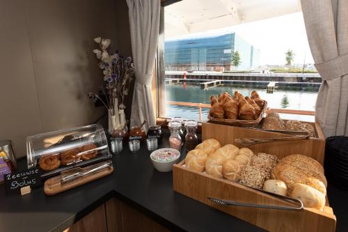 a counter topped with lots of different types of bread at Hotelboot Koningin Emma I Kloeg Collection in Vlissingen