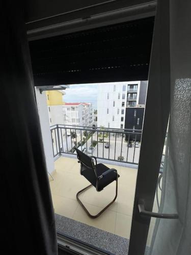 uma cadeira sentada na varanda de um edifício em 5th Floor 2+1 Apartment Sea View em Golem