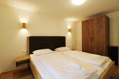 a bedroom with a large bed with two towels on it at Tannenhof Fischbach - Fewo 2 "Regenbogenforelle" - Schluchsee, 1 Schlafzimmer in Schluchsee