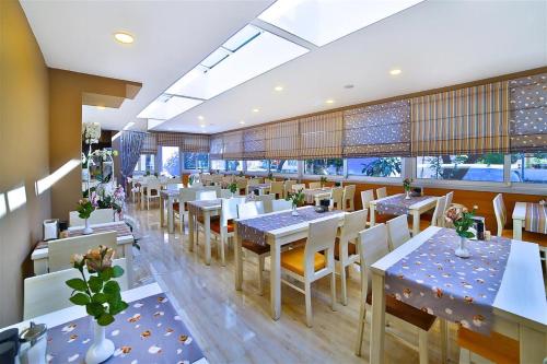 a restaurant with white tables and chairs and windows at The Hera Premium Hotels in Istanbul