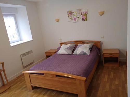 a bedroom with a bed with purple sheets and a window at Chambres d'hôtes Le Petit Angle in Saint-Broladre