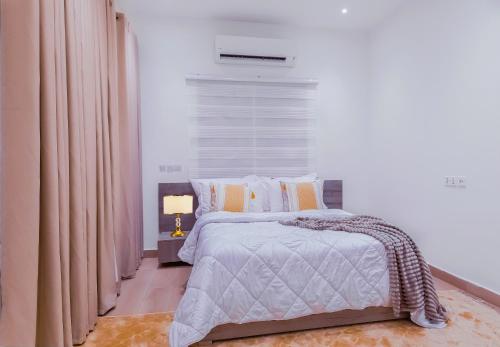 a bedroom with a bed and a window at Rosewood Chamber in Tema