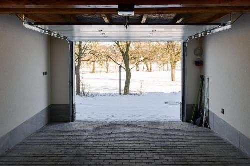 una habitación vacía con una puerta abierta a un campo cubierto de nieve en Apartmenty u Šípků OSTRAVA, en Vřesina