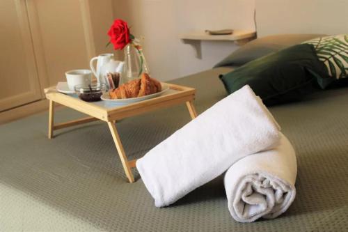 a table with a plate of food and a towel on a bed at Nuovo Hotel Giardini in Bra