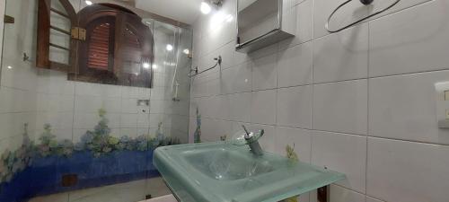 a bathroom with a green sink and a mirror at A Famosa CASA BRANCA Da Barra! Suíte 3 clássica! in Rio de Janeiro