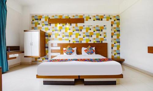 Dormitorio con cama grande y cabecero colorido en FabHotel Emirates Suites en Bangalore
