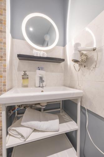 une salle de bain avec un lavabo blanc et un miroir dans l'établissement Résidence Les Cordeliers, à Avignon