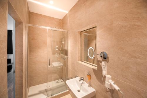 ein Bad mit einem Waschbecken und einer Dusche in der Unterkunft MiDoma, Self Check-In Hotel, Hannover Messe in Hannover
