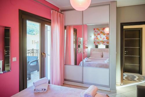 a bedroom with pink walls and a bed with a mirror at Villa Valentina in Kala Nera