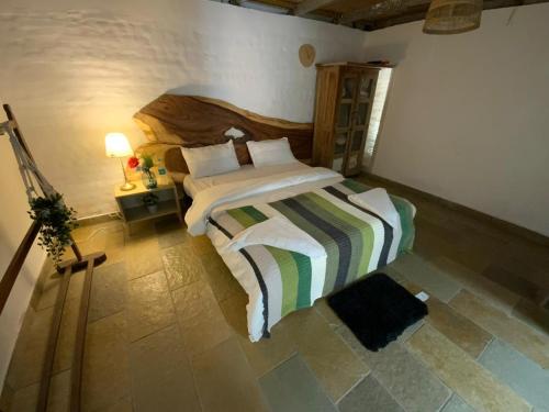 a bedroom with a large bed with a striped blanket at Jungle stay by Bilwa Estate in SanivÄrsante
