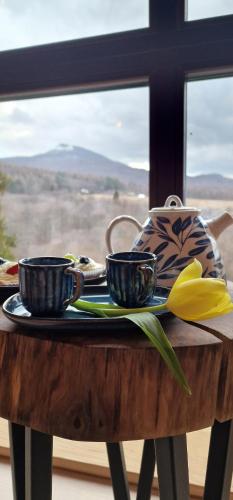 a table with two cups and a tea pot at Apartamenty komu gloria in Wetlina