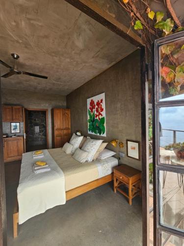 een slaapkamer met een groot bed en een raam bij Les Terrasses Suites in Calheta