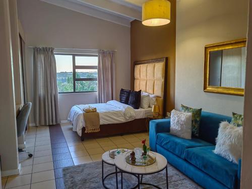 a living room with a blue couch and a bed at Tranquility facing Steyn City in Sandton