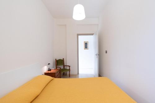 a bedroom with a bed with a yellow blanket at Villa Giulia in Alcamo