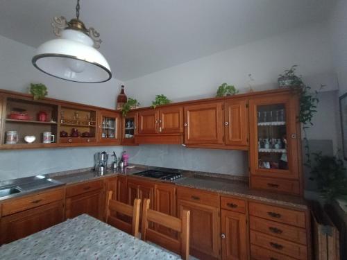 uma cozinha com armários de madeira, um lavatório e uma mesa em Guest House Attico Della Vittoria em Gabicce Mare