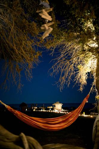 a hammock on the beach at night at Mojito Beach Rooms in Lachania