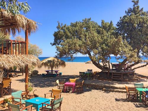 a group of tables and chairs on a beach at Mojito Beach Rooms in Lachania