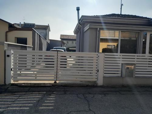 a white fence in front of a house at B&B DORMO AL MARE in Savio di Ravenna