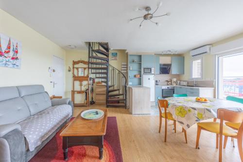 un salon avec un canapé et une table dans l'établissement Un Balcon sur le Port - Place de parking, à Courseulles-sur-Mer