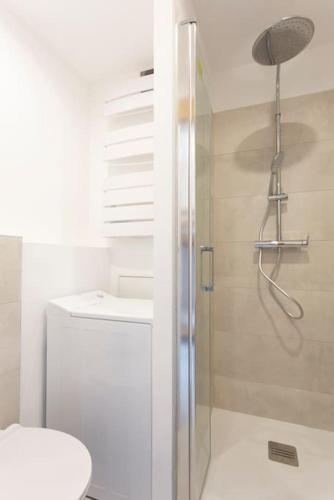 une salle de bain avec une douche avec des toilettes et un lavabo dans l'établissement Chez Olivier - Magnifique studio avec piscine, vue sur la mer et parking, à La Grande Motte