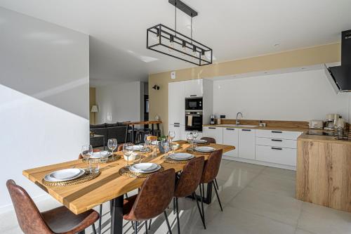 - une table à manger et des chaises dans la cuisine dans l'établissement Le Ter - Maison avec grand jardin, 5mn de la plage, à Ploemeur