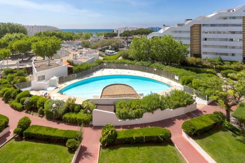une vue aérienne d'une piscine dans un jardin dans l'établissement Chez Olivier - Magnifique studio avec piscine, vue sur la mer et parking, à La Grande Motte