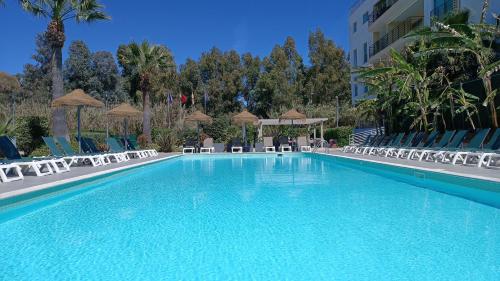 a large swimming pool with chairs and a building at Bayside Salgados in Albufeira