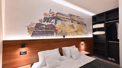 a bedroom with a bed with a painting on the wall at Tvrdjava Rooms in Novi Sad