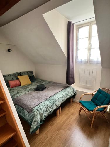 1 dormitorio con cama, ventana y silla en Maison La Madeleine hyper centre, en Vendôme