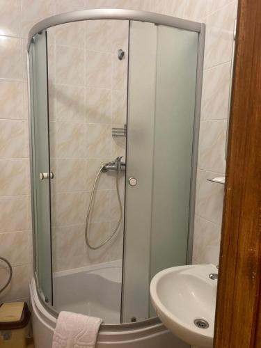 a shower with a glass door next to a sink at Hotel LaMa 2 in Kyiv