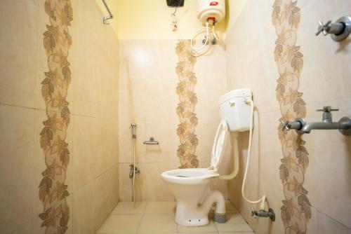 a bathroom with a toilet in a shower stall at Hotel Nilkantha in Mandarmoni